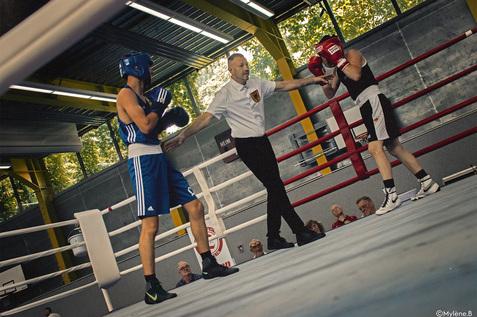 Schiedrichter zwischen zwei Boxern im Ring Schiedrichter zwischen zwei Boxern im Ring